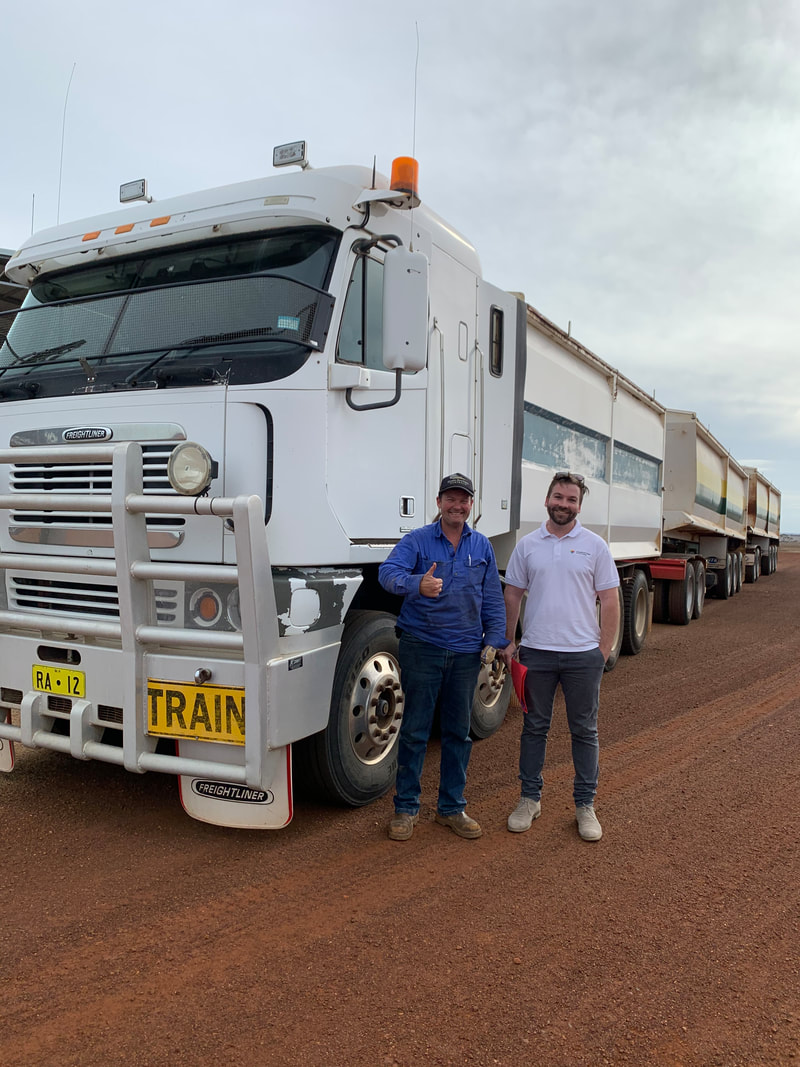 Client (left) and Occupational Therapist (right) standing next to a heavy combination truck